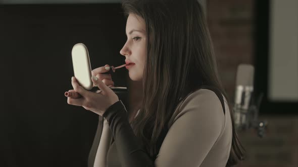 Bautiful Young Female Singer Applying Lips Makeup with Cosmetic Brush alt