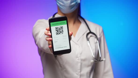 Woman Doctor in Medical Uniform Showing Vaccination Passport with Qr Code on Phone International alt