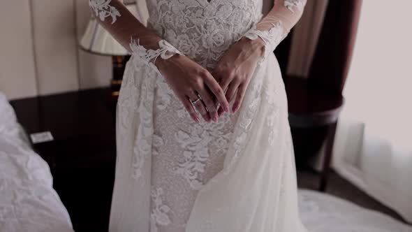 hands of the bride on a beautiful wedding dress alt