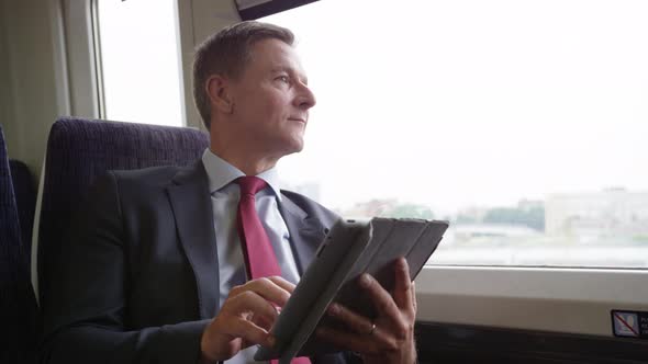 Commuter on his way to work looking at digital tablet