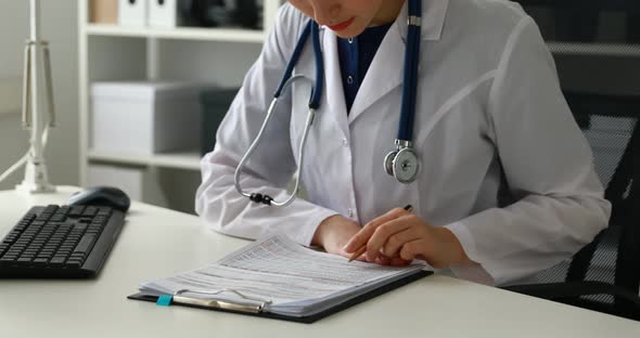 Cropped Image of Female Doctor Filling Documents