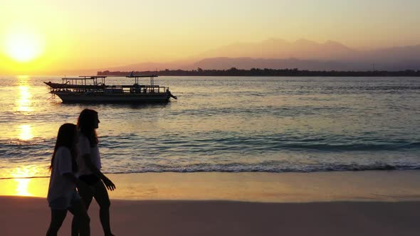 Ladies together tan on tranquil shore beach break by blue sea with white sand background of Indonesi alt