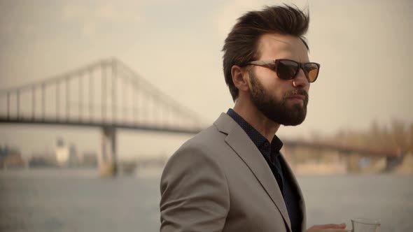 Bisinesman Drinking Tea Near Bridge. Businessman In Sunglasses.Man Drinking Coffee alt
