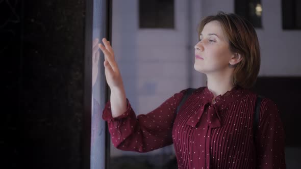 Woman using interactive touchscreen display at the street, scrolling and touching. Big navigation. alt