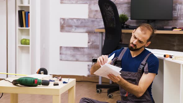 Confused Worker Rubbing His Head While Reading Instruction for New Furniture alt