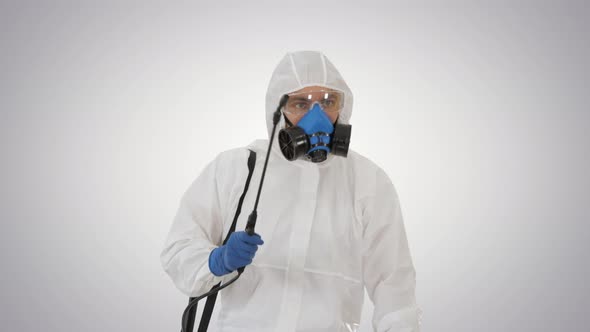 Virologist in Protective Uniform Walking and Disinfecting the Area on Gradient Background. alt