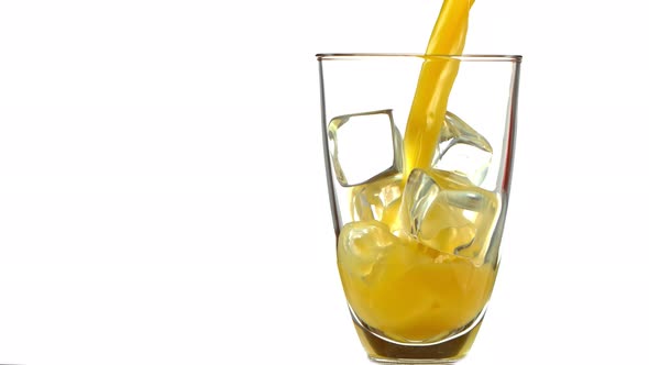 Super Slow Motion Shot of Pouring Fresh Orange Juice Into Glass with Ice Cubes at 1000 Fps alt