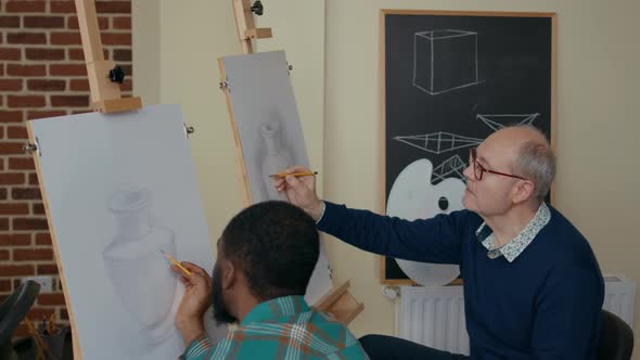 Team of Students Drawing Vase Model on Canvas in Art Class alt