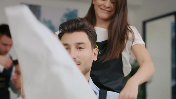 Handheld view of handsome man sitting in hair salon. Shot with RED helium camera in 8K alt