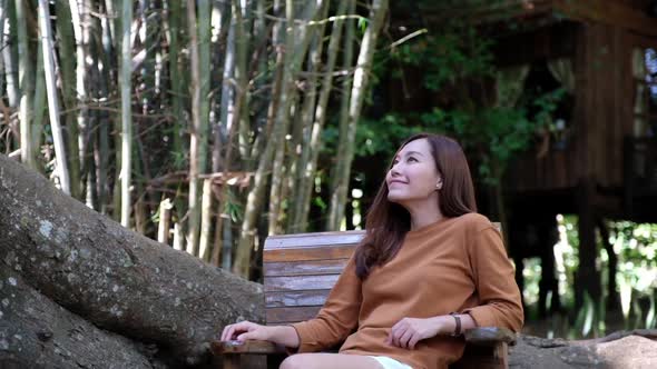 Slow motion of a beautiful young asian woman sitting and relaxing in the forest