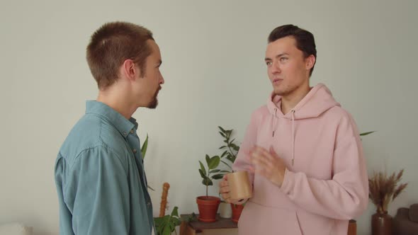 Standing in the Center of the Living Room One of Lgbt Men is Talking to His Boyfriend About the alt