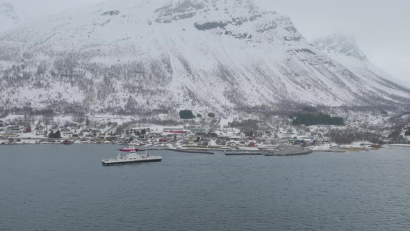 Kåfjord town centre and harbour at the foot of a mountain in Olderdalen, Norway. Overcast winter wea alt