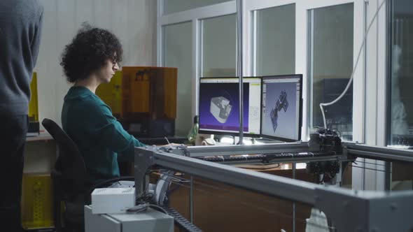 Young Designer Creating 3D Model Near Coworker alt
