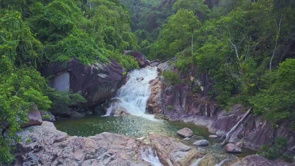 Drone Flies Over Beautiful Tropical Waterfall with Lake