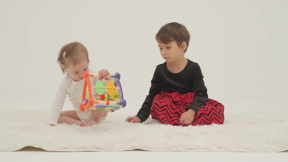 Toddler Girl Wearing Diaper and Her Sister Playing with Balls alt