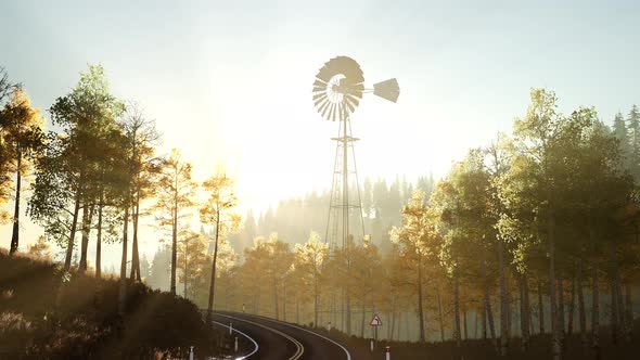 Typical Old Windmill Turbine in Forest at Sunset alt