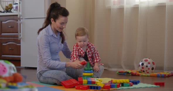 Happy Family of Mother Teaching Child To Learn Different Colors Building Colored Pyramid shot on RED alt