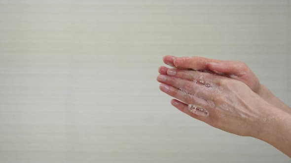 A Woman Washes Her Hands with White Soap Bubbles in Close-up. Demonstration of Hand Washing To alt