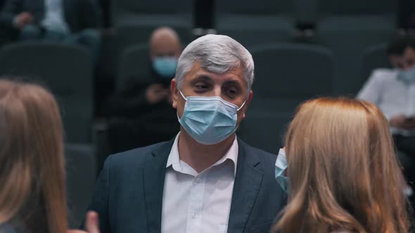 People in Medical Masks Chatting at a Conference