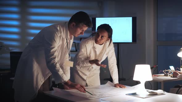 Middle Close Up of Two Electronics Development Engineers Checking Control Electronics Scheme alt