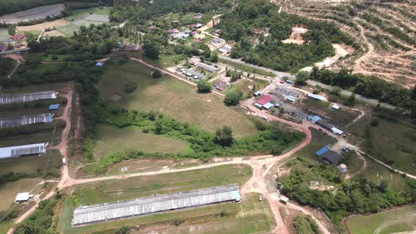 Aerial view oil chicken farm, village and hills during MCO