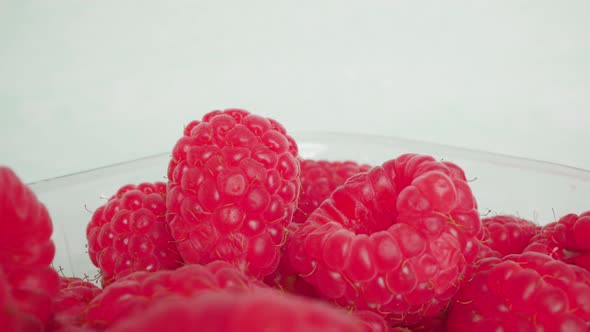 Raspberry Lies in Transparent Container on White Background alt