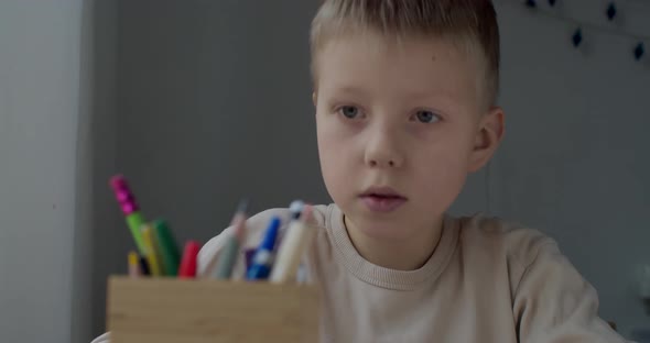 Close Up Portrait of Blonde Boy Drawing at Home Sitting at Table By Window Natural Light alt