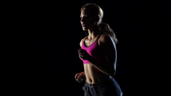 Wonderful Lass Is Running on a Black Background. Slow Motion alt