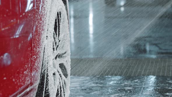 Auto Detailing  Covering a Red Car with a Cleaning Foam Using Spraying Machine alt