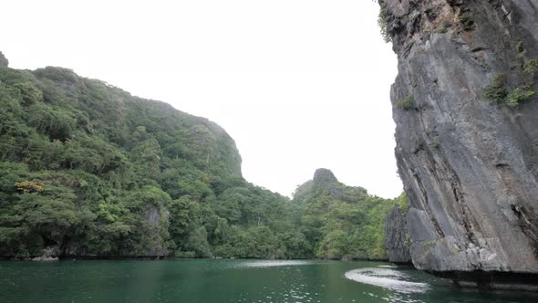 Slow motion dolly shot sailing in the famous Big Lagoon surrounded by limestone cliffs in El Nido, P alt