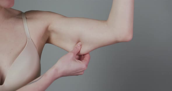 Chubby Woman Pinching Upper Arm Fat alt