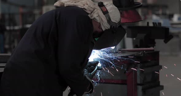 Welder At Work In A Steel Factory - Welding Metal With Sparks Flying