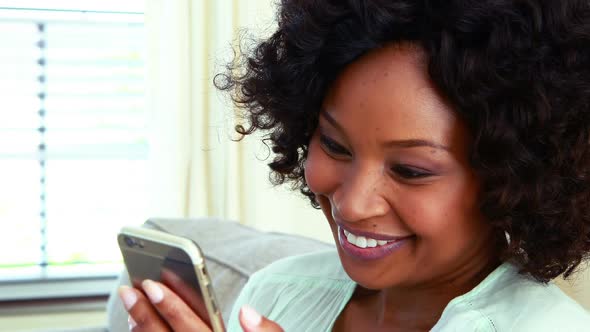Woman using mobile phone on sofa in living room 4k alt