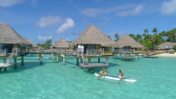 A man and woman couple on a outrigger canoe boat in Bora Bora tropical island. alt
