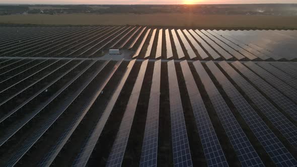 Aerial Drone View Into Large Solar Panels at a Solar Farm at Bright Sunset. Solar Cell Power Plants alt