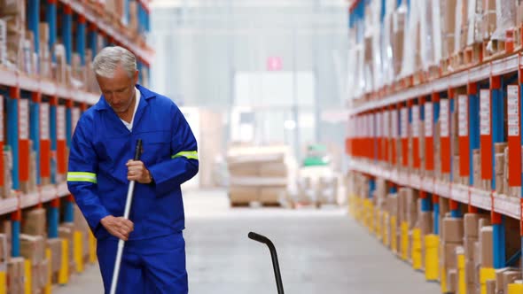Male warehouse worker moping floor alt