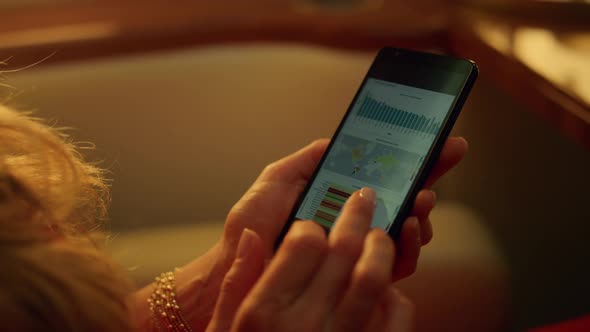 Hands Holding Data Charts on Cellphone Closeup alt