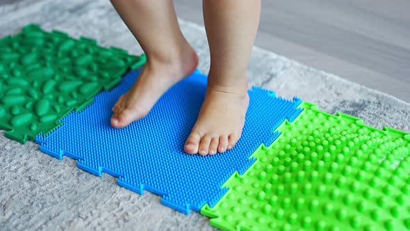 Close Up View of Little Girl Walks on a Massage Mat alt