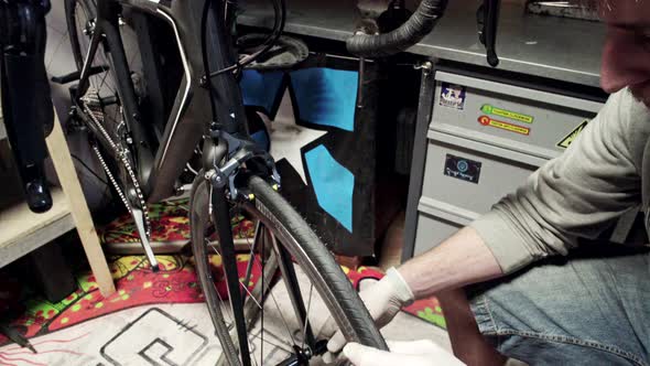 Mechanic Repairing Bicycle in Workshop