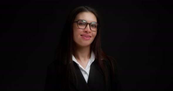 Business Woman with Glasses Winks with One Eye at the Camera