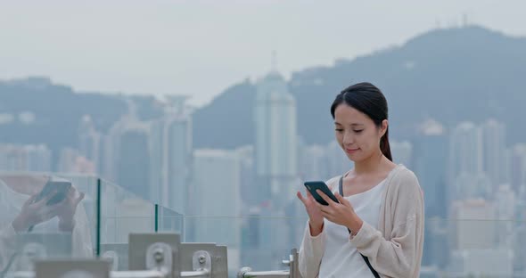 Woman look at mobile phone in Hong Kong city alt