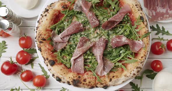 Delicious Pizza with Prosciutto Parma Ham Arugula Salad Rocket with Ingredients alt