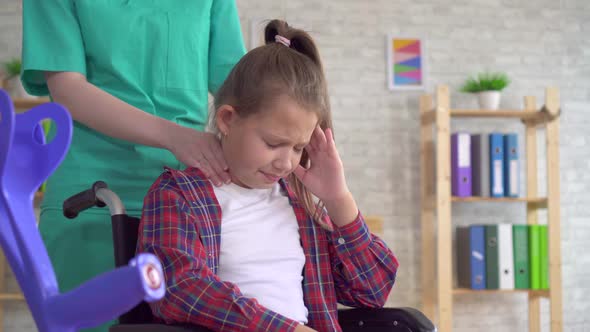 Doctor Masseur Doing Neck Massage To a Teenage Girl in a Wheelchair Close Up alt