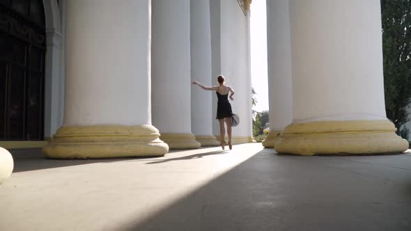 Extreme Wide Shot of Slim Young Woman Spinning on Tiptoes in Sunlight alt