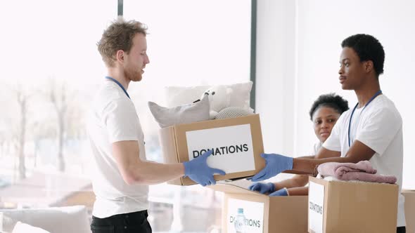Diverse Charity Volunteers Sorting Through Donated Goods alt