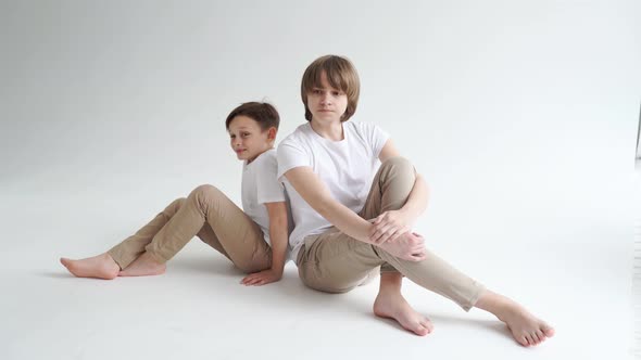 Mom Helps Pose Her Two Sons in Beige and White Clothes for a Photo Shoot alt