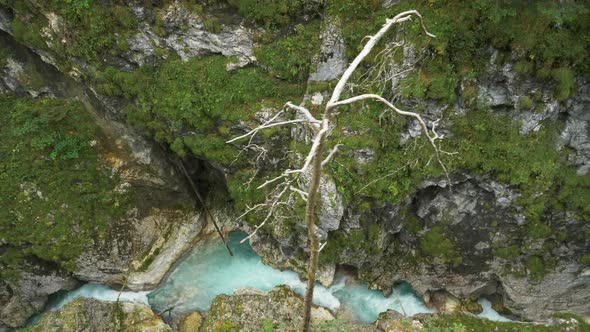 Overhead shot of river canyon with crystal clear water flowing alt