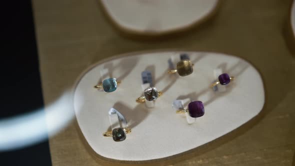 Golden Rings with Gemstones Indoors in Jewellery Store Closeup alt