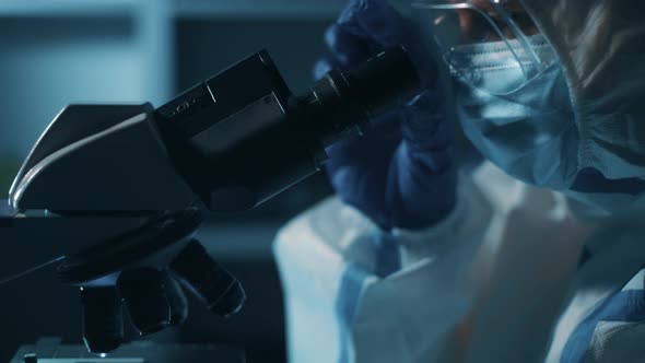 Woman Scientist Is Looking Into Microscope alt