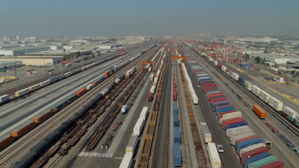 Aerial of railroad tracks and cargo containers stored in yard alt